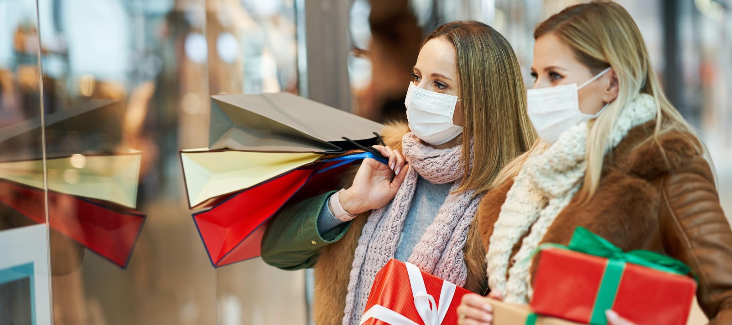 Two women Christmas shopping at a mall during the COVID pandemic
